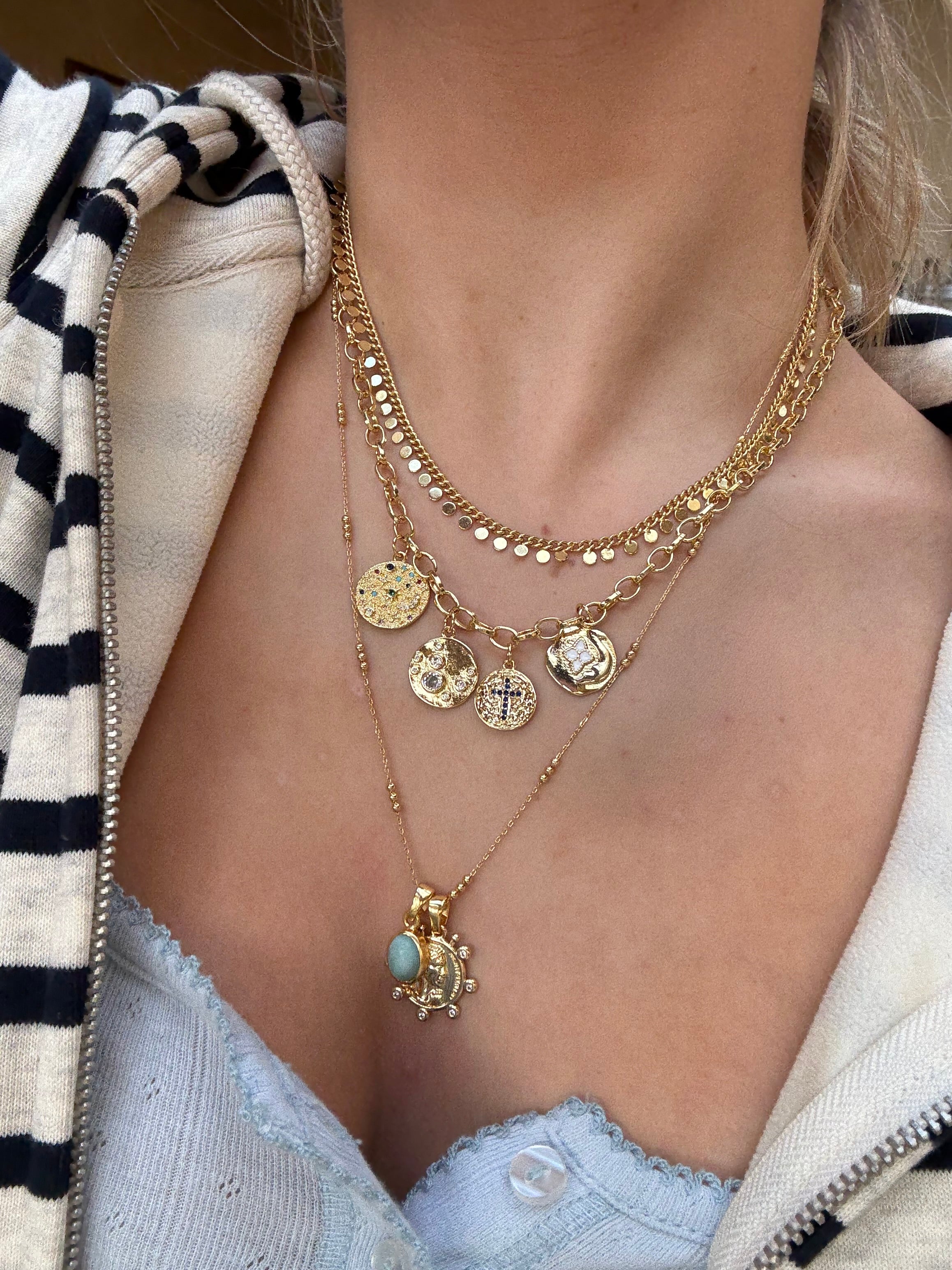 Layered gold necklaces styled for a cool jewellery stack