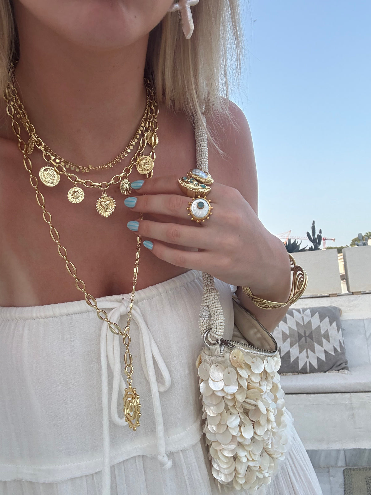 Summer jewellery stack with chunky gold necklaces